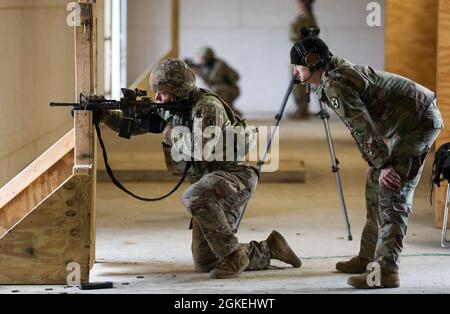 Ein Range Safety Officer mit Anvil Company, 2. Bataillon, 22. Infanterie-Regiment, 1. Brigade Combat Team, 10. Mountain Division (LI) führt den Vorsitz über einen Soldaten, der seinen M4 Karabiner während der M4 Qualifikation am 31. März 2021 in Fort Drum qualifiziert. N.Y. der Range Safety Officer ist für den sicheren Betrieb des Range verantwortlich und muss vor jeder geplanten Live-Fire-Übung eine Sicherheitseinweisung durchführen. Stockfoto