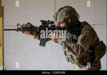 Ein Soldat mit Anvil Company, 2. Bataillon, 22. Infanterie-Regiment, 1. Brigade-Kampfteam, 10. Bergdivision (LI) richtet sein Visier kontinuierlich an einem Ziel in der stehenden unterstützten Position aus, während er am 31. März 2021 in Fort Drum mit dem M4-Karabiner qualifiziert. N.Y. der neue Kampftest der Armee macht die Qualifikation einzelner Waffen kampforientierter und besser anwendbar, wenn ein Feind eingesetzt wird. Stockfoto