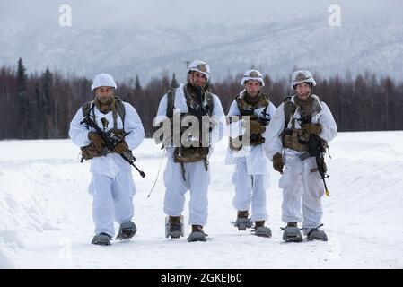 Fallschirmjäger der Armee, die dem 1. Bataillon, dem 501. Fallschirmjäger-Regiment, dem 4. Kampfteam der Infanterie-Brigade (Airborne), der 25. Infanterie-Division, der US-Armee Alaska, zugewiesen sind, begeben sich während eines simulierten Fallschirmangriffs in der Malemute Drop Zone auf der Joint Base Elmendorf-Richardson, Alaska, 31. März 2021 zum Rallyepunkt. Die Soldaten sind Teil der einzigen pazifischen Luftbrigade der Armee, die in der Lage ist, sich schnell weltweit zu entsenden, und werden für militärische Operationen unter strengen Bedingungen geschult. Stockfoto