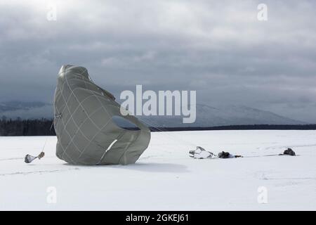 Ein Fallschirmjäger der Armee mit 1. Bataillon, 501. Fallschirmjäger-Regiment, 4. Infanterie-Brigade-Kampfteam (Airborne), 25. Infanterie-Division, U.S. Army Alaska, landet auf der Malemute Drop Zone während eines simulierten Fallschirmangriffs auf der Joint Base Elmendorf-Richardson, Alaska, 31. März 2021. Die Soldaten sind Teil der einzigen pazifischen Luftbrigade der Armee, die in der Lage ist, sich schnell weltweit zu entsenden, und werden für militärische Operationen unter strengen Bedingungen geschult. Stockfoto