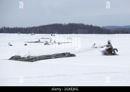 Fallschirmjäger der Armee, die dem 1. Bataillon, dem 501. Fallschirmjäger-Regiment, dem 4. Kampfteam der Infanterie-Brigade (Airborne), der 25. Infanterie-Division, der US-Armee Alaska, zugewiesen sind, erlangen ihre taktischen Fallschirmsysteme T-11 während eines simulierten Fallschirmeintritts in der Malemute Drop Zone auf der Joint Base Elmendorf-Richardson, Alaska, 31. März 2021. Die Soldaten sind Teil der einzigen pazifischen Luftbrigade der Armee, die in der Lage ist, sich schnell weltweit zu entsenden, und werden für militärische Operationen unter strengen Bedingungen geschult. Stockfoto