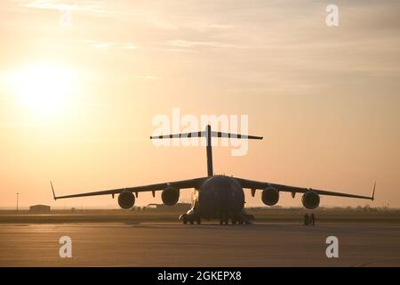 Die Sonne geht hinter einem C-17 Globemaster III der US Air Force auf dem Altus Air Force Base, Oklahoma, 2. April 2021 auf. Etwa 29 Flugzeuge nahmen an einer Large Formation Exercise (LFE) Teil, die die Fähigkeit der Basis zeigte, Flugzeugschäden durch Annäherung an Unwetter zu vermeiden. Stockfoto