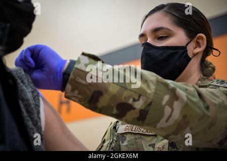 U.S. Air Force Staff Sgt. Victoria Goluszka, 182nd Medical Group, aerospace medical technician places bandage on patient in the Byron High School, Byron, Illinois, April 1, 2021. Goluszka is currently serving in the Illinois National Guard to administer COVID-19 vaccinations to Illinois residents. Stockfoto