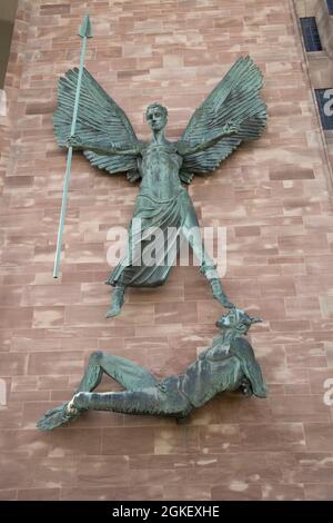 Jacob Epsteins Bronzeskulptur St. Michaels Sieg über den Teufel an der Sandsteinwand der neuen Coventry Cathedral Warwickshire UK Stockfoto