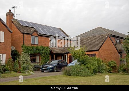 Modernes Einfamilienhaus aus rotem Backstein mit Solar-PV-Paneelen auf gefliestem Dach Bidford auf Avon Warwickshire UK Stockfoto