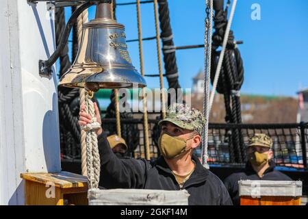 Der US Navy Petty Officer der 2. Klasse, Agapito Ramos, ein Gehilfe des Bootsmörder, der dem Navy Cargo Handling Bataillon 1, Williamsburg, Virginia, zugewiesen wurde, läutet am 3. April 2021 im Boston Harbour die Glocke der USS Constitution ein. Ramos sagte, dass die Wiederanwerbung an Bord des historischen Schiffes eine Ehre war, und er ist stolz darauf, die Gelegenheit gehabt zu haben. Ramos ist derzeit als Teil der Gruppe von Dienstmitgliedern nach Boston entsandt, die die Federal Emergency Management Agency im Community Impfcenter in Boston unterstützen. Das U.S. Northern Command setzt sich über die U.S. Army North weiterhin für eine fortgesetzte, flexible Depar ein Stockfoto