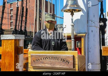 US Navy Petty Officer 2nd Class Agapito Ramos, ein Bootsmann, der dem Navy Cargo Handling Bataillon 1, Williamsburg, Virginia, zugewiesen wurde, steht nach seiner sechsjährigen Neuaufstellung am 3. April 2021 in Boston Harbor auf dem Podium der USS Constitution. Ramos hatte die Ehre, seine Neuauflistungspapiere auf dem Schiffspodium zu unterzeichnen, eine seltene Gelegenheit, die viele Segler nicht bekommen. Ramos ist derzeit als Teil der Gruppe von Dienstmitgliedern nach Boston entsandt, die die Federal Emergency Management Agency im Community Impfcenter in Boston unterstützen. U.S. Northern Command, durch U.S. Army North Stockfoto