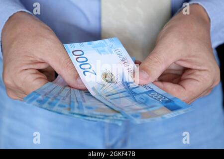 Russische Rubel in den männlichen Händen, Barzahlung, Gehalt oder Bestechung Konzept. Mann in Bürokleidung mit Papierwährung Russlands Stockfoto