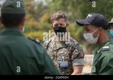 Eine US-Marine beantwortet Fragen an Mitglieder der Royal Moroccan Armed Forces nach einem praktischen Anwendungsszenario während einer Sprengstoffdeponie in der Nähe von Kenitra, Marokko, 6. April 2021. Marineinfanteristen, Matrosen und Mitglieder der Utah National Guard nehmen an der humanitären Minenaktion, der Sprengstoffbeseitigung in Marokko 2021 Teil, wo US-EOD-Techniker die EOD-Validierung der Royal Moroccan Armed Forces (FAR)-Soldaten der Stufe zwei beaufsichtigen, um die Bemühungen zur Schaffung einer EOD-Fähigkeit innerhalb DER FAR fortzusetzen. Stockfoto