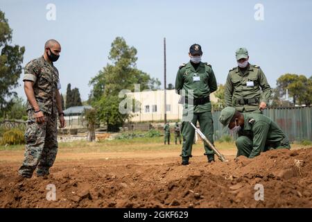 Eine US-Marine beobachtet ein Mitglied der Royal Moroccan Armed Forces während eines praktischen Anwendungsszenarios während einer Sprengstoffdeponie-Klasse (EOD) in der Nähe von Kenitra, Marokko, 6. April 2021. Marineinfanteristen, Matrosen und Mitglieder der Utah National Guard nehmen an der humanitären Minenaktion, der Sprengstoffbeseitigung in Marokko 2021 Teil, wo US-EOD-Techniker die EOD-Validierung der Royal Moroccan Armed Forces (FAR)-Soldaten der Stufe zwei beaufsichtigen, um die Bemühungen zur Schaffung einer EOD-Fähigkeit innerhalb DER FAR fortzusetzen. Stockfoto