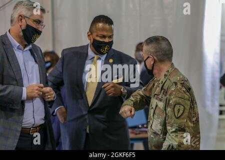 US Army Brig. General Patrick Thibodeau, rechts, der Kommandant mit zwei Status für den Bundesstaat Indiana, Indiana Gov. Eric Holcomb, links, und der stellvertretende Bürgermeister von Gary, Trent McCain, begrüßen sich bei der Eröffnung des staatlich geführten, staatlich unterstützten COVID-19 Community Impfzentrums in Gary, Indiana, am 6. April 2021. Die Eröffnung des CVC wurde mit einer Pressekonferenz unter Beteiligung von Vertretern des Bundesstaates Indiana und der Federal Emergency Management Agency begonnen. Das U.S. Northern Command setzt sich über die U.S. Army North weiterhin für die kontinuierliche, flexible Unterstützung des Verteidigungsministeriums ein Stockfoto