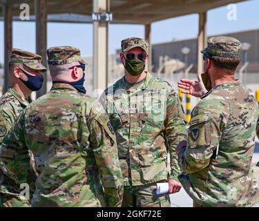 Der US-Armeekapitän Stephen Long, Executive Officer, 401. Armee-Feldunterstützungsbataillon-Katar (Mitte), hört Oberst Michael F. LaBrecque, Kommandeur, 401. Armee-Feldunterstützungsbrigade (rechts), während er den Zeitplan und die Erwartungen für eine vollständige AFSBn-Katar-Deaktivierung im Camp As Sayliyah, Katar, April 6, diskutiert. Stockfoto