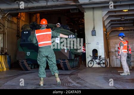 Eine US-Marine mit II Marine Expeditionary Force Ground leitet einen Austausch des logistischen Fahrzeugsystems (LVSR) vom USNS PFC Dewayne T. Williams (T-AK-3009) während der Übung Dynamic Cape (DC21.1) am 7. April 2021 im Military Ocean Terminal Sunny Point, North Carolina. DC 21.1 ist eine Befehls- und Kontrollübung, die eine umkämpfte Umgebung simuliert, um die Einsatzbereitschaft zwischen den Partnerländern der II Marine Expeditionary Force und anderen Einheiten des Verteidigungsministeriums zu verbessern. Stockfoto