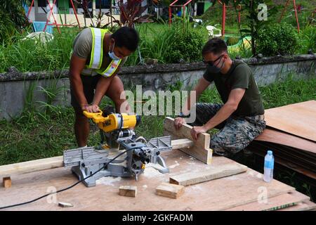 Philippinische Armee Ed Paul Mariano (links), 514. Ingenieur-Brigade-Bauingenieur und U.S. Marine Lance CPL. Tyler Smith (rechts), 9th Engineer Support Battalion Combat Engineer, Schnitt während der Balikatan 21 in Barangay Ilosong, Plaridel, Ph., 7. April 2021 Holz für den Bau von Säulenschalungen für ein Gebäude mit zwei Klassen. Balikatan, jetzt in seinem 36. Jahr, ist ein Beispiel für die langjährige Freundschaft zwischen den Philippinen und den Vereinigten Staaten in Aktion. Stockfoto