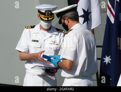 210407-N-FG807-1011 SAN DIEGO (7. April 2021) Cmdr. Ted Seymour, Kommandooffizier der Royal Australian Navy (RAN) des Lenkflugkörper-Zerstörers HMAS Sydney (rechts) der Hobart-Klasse, überreicht die Auszeichnung - Commander, Silver Commander der australischen Flotte an Cmdr. Robert Eilers, U.S. Navy (links) während einer Preisverleihung an Bord von Sydney auf der Naval Station San Diego am 7. April. Eilers, der als Foreign Disclosure Officer dem Naval Surface and Mine Warfighting Development Center (SMWDC) zugewiesen wurde, erhielt die Auszeichnung in Anerkennung seiner Beiträge zur Australian-United States Alliance. Hauptsitz in S Stockfoto