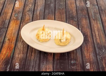 Spanische Tapa mit russischem Salat in zwei Portionen mit Mayonnaise auf weißem Teller Stockfoto