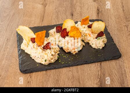 Großer russischer Salat mit pommes Frites und Süßkartoffeln auf schwarzem Schiefer Stockfoto