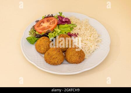 Falafel-Ballmenü mit Salat und Tomaten und weißem Reis, serviert in einem pakistanischen Kebab-Restaurant Stockfoto