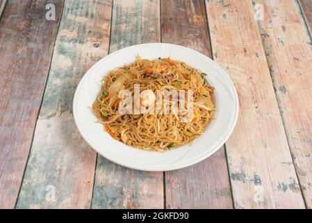 Chinesische Reisnudeln mit Garnelen und Gemüse im Wok anbraten. Bohnensprossen und Rindfleisch mit Sojasauce anbraten Stockfoto