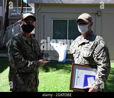 DIEGO GARCIA, Britisches Territorium im Indischen Ozean (08. April 2021) – der Leiter des Elektroniktechnikers, Jason G. Gregory, der führende Chief Petty Officer des US Naval Support Facility Operations, Diego Garcia, erhält eine Armed Forces Service Medal von Capt. R. Wade Blizzard, dem Kommandanten von NSF, Diego Garcia, Während einer Preisverleihung am 08. April 2021. NSF Diego Garcia bietet Logistik-, Service-, Freizeit- und administrative Unterstützung für US- und alliierte Truppen, die im Indischen Ozean und im Arabischen Golf eingesetzt werden. Stockfoto