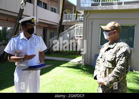 DIEGO GARCIA, Britisches Territorium im Indischen Ozean (08. April 2021) – Royal Navy Cmdr. Steven R. Drysdale, britischer Vertreter des Britischen Territoriums im Indischen Ozean, hält während einer Preisverleihung am 08. April 2021 eine Rede über den Leiter des Elektroniktechnikers Jason G. Gregory, den führenden Chief Petty Officer des US Naval Support Facility Operations Diego Garcia. NSF Diego Garcia bietet Logistik-, Service-, Freizeit- und administrative Unterstützung für US- und alliierte Truppen, die im Indischen Ozean und im Arabischen Golf eingesetzt werden. Stockfoto