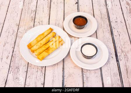 Teller mit Olivenöl gebratenen Käseflöten mit zwei schwarzen Behältern mit Dipping-Saucen Stockfoto