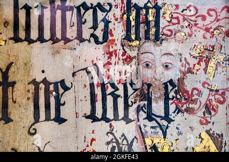 Binham Priory Rood-Bildschirm. Mittelalterliches Gemälde eines unbekannten heiligen, der ein Kreuz hält, das durch einen schwarz-Buchstaben übermalten Text aus Cranmers Bibel von 1539 zeigt. Stockfoto