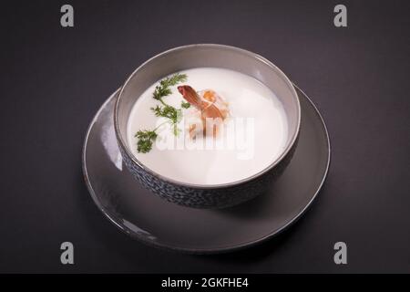 Käsesauce mit Pilzen, Garnelen und Petersilie in einer Keramikschale mit Untertasse Stockfoto