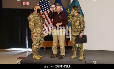 Tom Sitter (Mitte), Veteran des Zweiten Weltkriegs und Sprecher von Days of Remembrance zeigt die Münze, die er von dem Generalmajor Miguel A. Castellanos (links), dem Kommandanten, 84. Trainingskommando, in Begleitung von Brig erhalten hat. General Stacy Babcock, Kommandant General, 86. Training Division, in Fort McCoy, Wis., April 9. Stockfoto