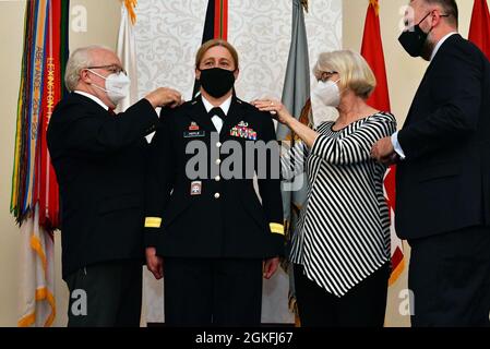 US Army Brig. Gen. Heidi J. Hoyle, die kommandierende Generaloberin des Military Surface Deployment and Distribution Command, lässt ihre Beförderung zu Hauptstars von ihren Eltern und ihrem Mann während einer Zeremonie zu ihren Ehren im Veranstaltungszentrum auf der Scott Air Force Base, Abb. 9. April 2021 festmachen. Stockfoto