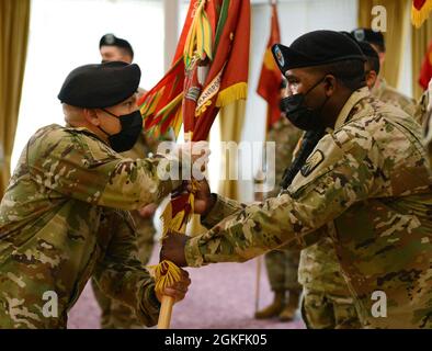 US Army LT. Col. Matthew C. Rivera (links), Kommandant übergibt die Farben an Command Sgt. Maj. Ricky M. Noid (rechts), beide mit 39. Transportbataillon während einer Kommandowechselzeremonie im Armstrong’s Club, Kaiserslautern, Deutschland, 9. April 2021. Rivera übernahm das Kommando über die Einheit von Oberstleutnant Brandon H. Ungetheim. Stockfoto