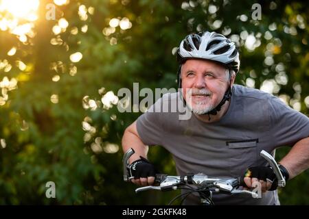 Senior Mann auf dem Fahrrad, Radfahren draußen, genießen schönen, sonnigen Sommertag, gesundes Lifestyle-Konzept Stockfoto