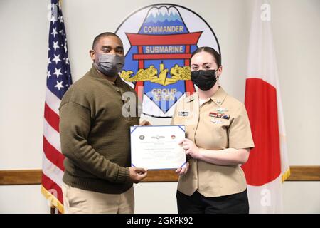 YOKOSUKA, Japan (Apr. 9, 2021) Information Systems Technician 2nd Class Brittany Cure, aus Springfield, Ohio, wurde dem Commander der N6-Abteilung der Submarine Group 7 zugewiesen und erhält den Anstecker Information Dominance Warfare Specialist. Commander, Submarine Group 7, leitet U-Boot-Aktivitäten im gesamten westlichen Pazifik, im Indischen Ozean und im Arabischen Meer: Zwei U-Boot-Boote, die im Vorlauf eingesetzt wurden, USS Frank Cable (AS 40) und USS Emory S. Land (AS 39), fünf Überwachungsschiffe mit gezogenen Sensorsystemen und drei ozeanographische Vermessungsschiffe, wenn sie für einen Einsatz gegen U-Boot-Kriegsführung im Theater beauftragt wurden Stockfoto