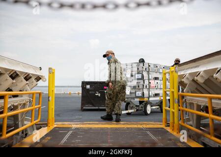 Aviation Ordnanceman 3rd Class Juan Torres aus Milwaukee, der der Waffenabteilung von USS Gerald R. Ford (CVN 78) zugewiesen wurde, transportiert während einer Munitionsaufladung auf dem Flugdeck am 9. April 2021 die Munitionsaufzüge auf einen der fortschrittlichen Waffensysteme des Schiffes. Ford befindet sich im Hafen von Norfolk, um im Rahmen ihrer 18-monatigen Test- und Testphase nach der Auslieferung eine geplante Wartungsmöglichkeit zu erhalten. Stockfoto