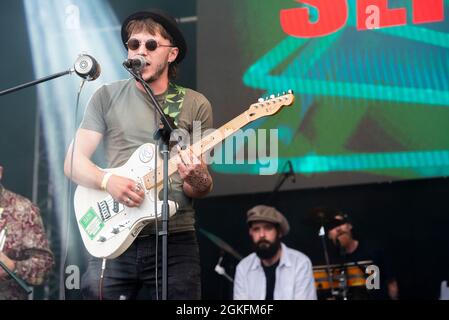 Slim Pickings Band, die auf einem Musikkonzertfestival in Garon Park, Southend on Sea, Essex, Großbritannien, auftrat. Gitarrist spielt und singt Stockfoto