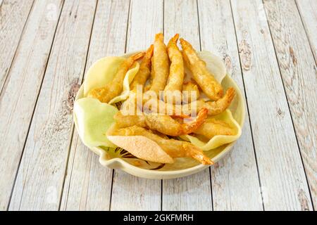 Gebratene Garnelen in Tempura mit chinesischem Brot auf Schüssel und weißem Holztisch Stockfoto