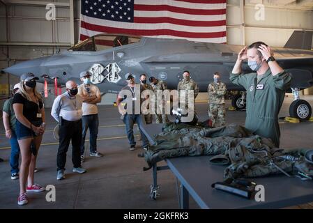 Maj. Aaron Stevens (rechts), ein F-35 Lightning II Pilot bei der 94th Operations Group, informiert Arbeitgeber über die 94th FW Employer Day 2021 auf der Luke Air Force Base, Arizona., 10. April 2021. Die Arbeitgeber besichtigten eine Feldküche, beobachteten Taktiken-Demonstrationen der Sicherheitskräfte und erhielten Briefings zu Waffen, Flugzeugwartung und den F-35 Lightning II- und F-16-Kampfflugzeugen von Falcon. Stockfoto