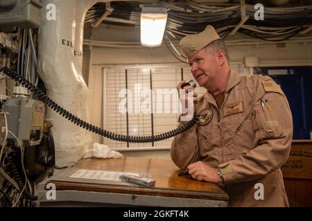 210411-N-AY174-1051 DUQM (11. April 2021) – Vice ADM. Samuel Paparo, Kommandant des U.S. Naval Forces Central Command (NAVCENT), der 5. US-Flotte und der Combined Maritime Forces, spricht während eines Besuchs in Duqm, Oman, im April 11, über das allgemeine Ankündigungssystem des Schiffes an Bord des Flugzeugträgers USS Dwight D. Eisenhower (CVN 69). Die Eisenhower Carrier Strike Group wird im Einsatzgebiet der 5. US-Flotte eingesetzt, um Marineinteroperationen zu unterstützen, um die maritime Stabilität und Sicherheit in der Zentralregion zu gewährleisten und den Mittelmeerraum und den Pazifik über den Wester zu verbinden Stockfoto