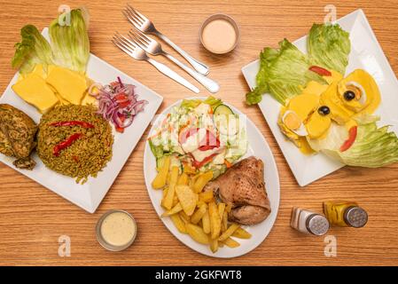 Set von typischen peruanischen Gerichten wie Huancaina-Kartoffeln, Chaufa-Reis, gebratenes Huhn mit Kartoffeln Stockfoto