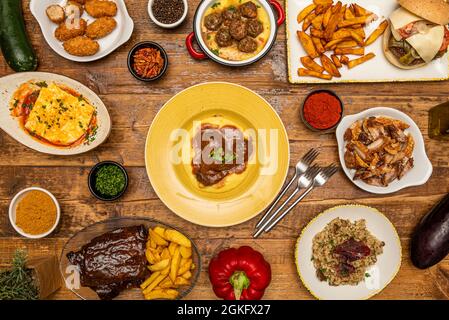 Köstliche Kombination von Gerichten der spanischen Gastronomie und italienischen Speisen. BBQ Rippchen, Risotto, Schweinebacke, Schweinebraten, Schinkenkroketten, Hackbraten, Gabeln Stockfoto