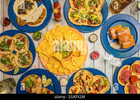 Auswahl an beliebten mexikanischen Gerichten. Tacos al Pastor, Maisnachos mit Guacamole, Cochinita pibil Tacos, Maiskuchen, Chicken Tinga Tacos. Stockfoto