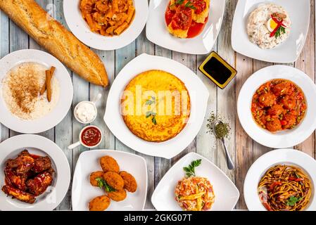 Eine Auswahl an beliebten Gerichten in einer spanischen Tapas- und Fusion-Taverne. Russischer Salat, Kartoffelomelett, Reis mit Milch, Hackbraten in Sauce, Kabeljaukroketten, ba Stockfoto