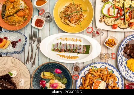 Mediterrane Gerichte und gegrilltes Gemüse mit rotem Thunfisch, zerschlagene Hähnchenstreifen, Kichererbsen-Eintopf, Schweinebacke. Stockfoto