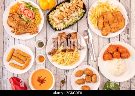 Set von Gerichten der beliebten spanischen Küche. Schinkenkroketten, gebratene Schweinerippchen, Huhn cesar Salat, Hühnerfilet Mailänder, andalusischer Gazpacho, Fleischbällchen Stockfoto