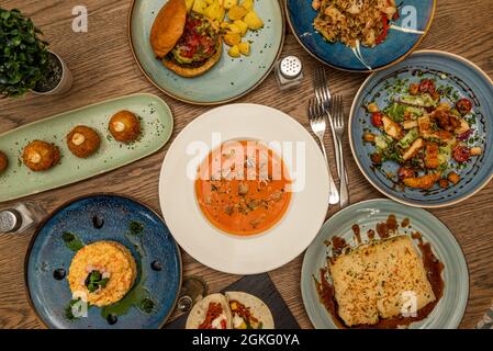 Auswahl an spanischen und mediterranen Gerichten. Salmorejo, Hühnersalat, serrano-Schinkenkroketten, russischer Salat, cremiger Reis und Lasagne Stockfoto