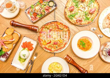 Probieren Sie die typische italienische Gastronomie mit den üblichen Pizzen, Burrata-Salat, Spaghetti Bolognese vom Zenit aus Stockfoto