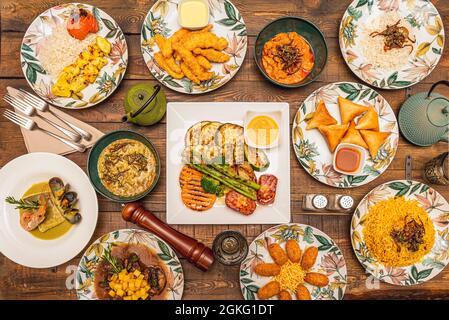 Mediterrane Gerichte, orientalische Reisgerichte und spanische Eintöpfe. Gegrilltes Gemüse und Waldbeeren, Seehecht in grüner Sauce, Kroketten, Gemüse-sam Stockfoto