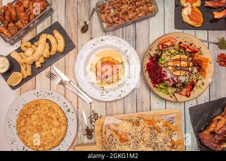 Tapas und spanische Küche. Entrecote, Ziegensalat, Kroketten, Flügel, Tintenfisch, Spitze, Paella, Tapas, Tintenfisch, Salat, Rührei, gegrillter Oktopus Stockfoto