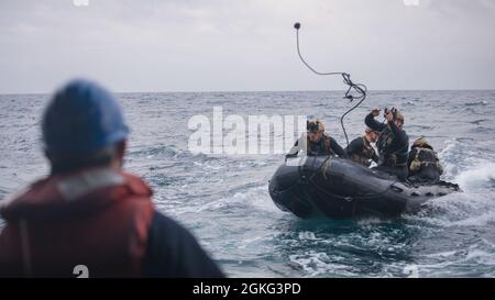 PAZIFISCHER OZEAN (13. April 2021) U.S. Marines mit der All Domain Reconnaissance Detachment, 11th Marine Expeditionary Unit, werfen während der Kampfpanzer-Trainingseinsätze im Kautschukbereich, am 13. April, eine Sicherheitsschnur auf das Amphibiendock-Landungsschiff USS Pearl Harbor (LSD 52). Die Marineinfanteristen und Matrosen der 11. MEU führen Routineoperationen mit der Amphibious Ready Group von Essex durch. Pearl Harbor ist Teil der ARG von Essex in der dritten US-Flotte. Stockfoto