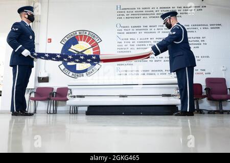 Airman 1st Class Ashton Martin, links, 341st Missile Security Forces Squadron Defender und Senior Airman Cho Yang, rechts, 841. Missile Security Forces Squadron Defender, beide aktuelle 341st Missile Wing Base Honor Guard ehren Wachmänner, üben beim Training am 13. April 2021 auf der Malmstrom Air Force Base das Falzen einer amerikanischen Flagge, Met. Während der militärischen Beerdigungen falten Honor Guard Airmen die Flagge und präsentieren sie den nächsten Angehörigen des gefallenen Militärs mit einem Gruß. Stockfoto